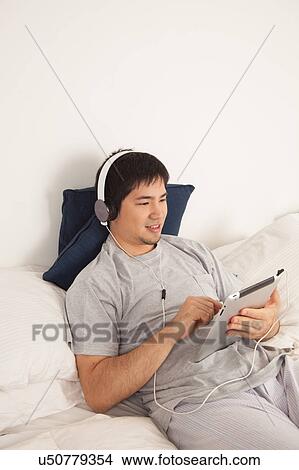 Man listening to music with the tablet View Large Photo Image Picture - Man listening to music with the tablet. Fotosearch