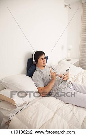 Stock Image - Man listening to music with the tablet. Fotosearch