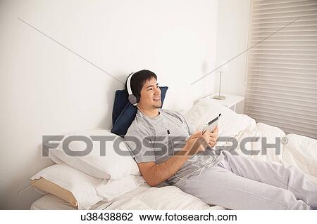 Stock Image - Man listening to music with the tablet. Fotosearch