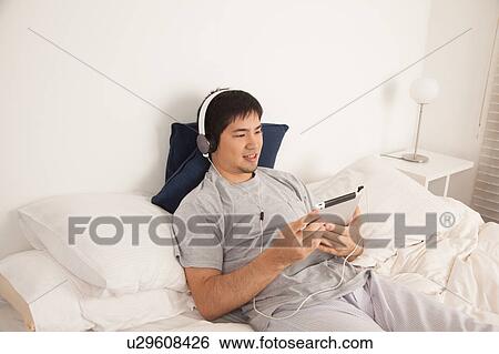Stock Photograph - Man listening to music with the tablet. Fotosearch