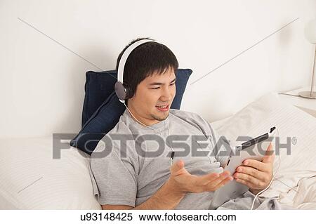 Stock Photography - Man listening to music with the tablet. Fotosearch