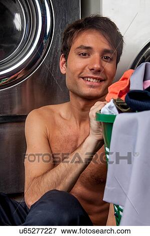 Stock Photo - Man looking at camera in the laundry. Fotosearch