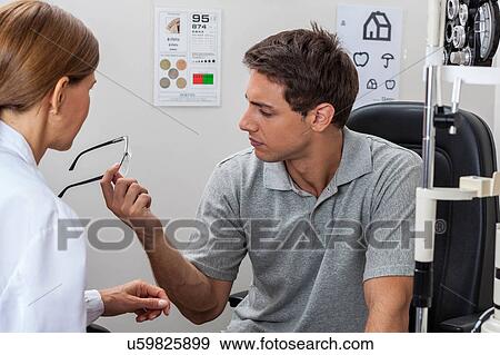Stock Photo - Man looking at glasses. Fotosearch