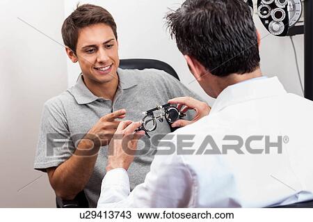 Stock Image - Man looking at the glasses. Fotosearch