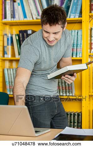 Stock Photo - Man looking his notebook. Fotosearch