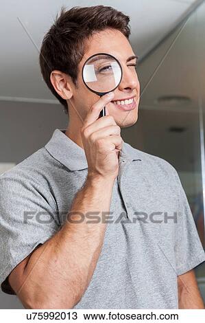 Man looking through loupe View Large Photo Image Stock Image - Man looking through loupe. Fotosearch