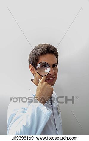 Man looking through loupe View Large Photo Image Stock Photo - Man looking through loupe. Fotosearch