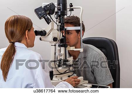 Man looking through the keratometer View Large Photo Image Picture - Man looking through the keratometer. Fotosearch
