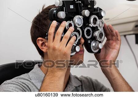 Man looking through the keratometer View Large Photo Image Stock Photo - Man looking through the keratometer. Fotosearch