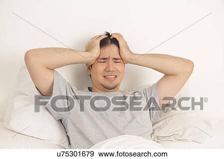 Stock Photo - Man lying with headache. Fotosearch