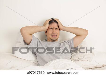 Man lying with headache View Large Photo Image Stock Photo - Man lying with headache. Fotosearch