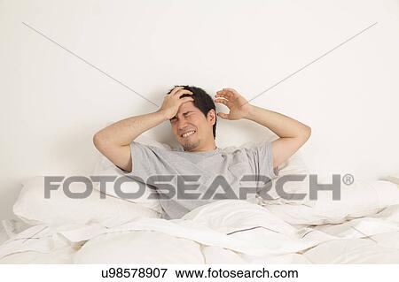 Man lying with headache View Large Photo Image Stock Photo - Man lying with headache. Fotosearch