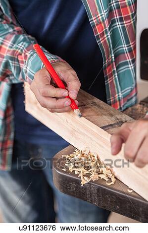 Man marking wood with a pencil View Large Photo Image Stock Photograph - Man marking wood with a pencil. Fotosearch