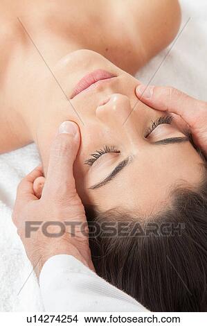 Picture - Man massaging a woman on her face. Fotosearch