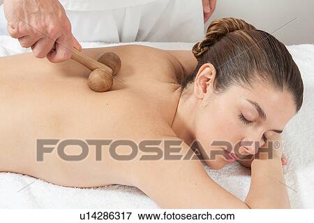 Stock Photo - Man massaging a woman with a special tool. Fotosearch