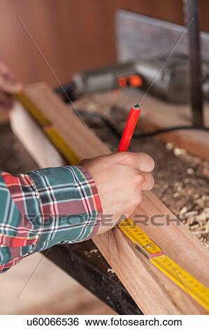 Man measuring a piece of wood View Large Photo Image Stock Photograph - Man measuring a piece of wood. Fotosearch