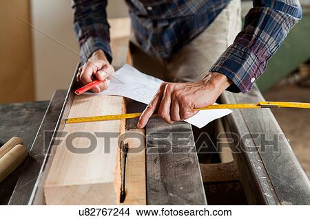 Man measuring a plank View Large Photo Image Picture - Man measuring a plank. Fotosearch