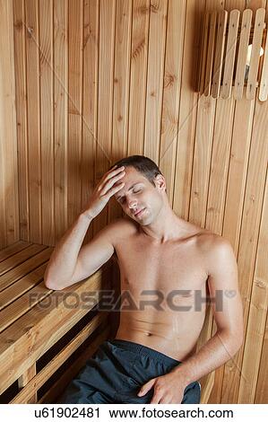 Stock Image - Man perspiring inside the sauna. Fotosearch