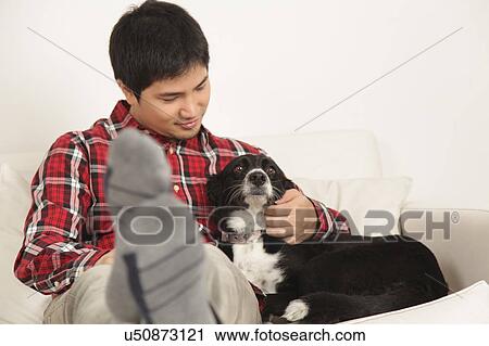 Stock Image - Man petting a dog. Fotosearch