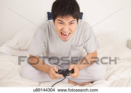Picture - Man playing video games and shouting. Fotosearch