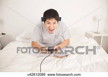 Man playing video games and shouting View Large Photo Image Stock Photo - Man playing video games and shouting. Fotosearch