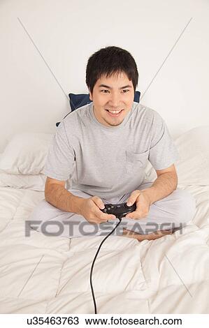 Stock Image - Man playing video games. Fotosearch
