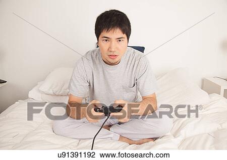 Stock Image - Man playing video games. Fotosearch