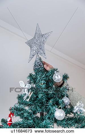 Man putting the star of christmas tree View Large Photo Image Stock Image - Man putting the star of christmas tree. Fotosearch