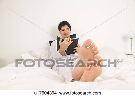 Man reading a book and smiling View Large Photo Image Picture - Man reading a book and smiling. Fotosearch
