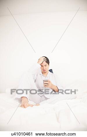 Man reading by phone View Large Photo Image Stock Image - Man reading by phone. Fotosearch