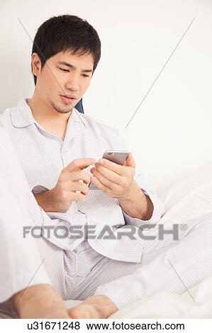 Man reading by phone View Large Photo Image Stock Photo - Man reading by phone. Fotosearch