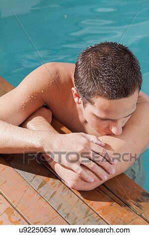Picture - Man rest in the edge of the pool. Fotosearch