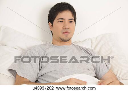 Man resting in his bed View Large Photo Image Stock Image - Man resting in his bed. Fotosearch