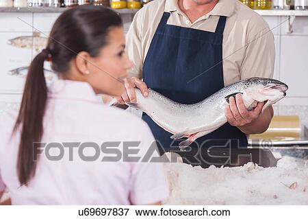 Stock Photo - Man selling a pink salmon. Fotosearch