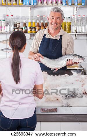 Stock Photo - Man showing a pink salmon. Fotosearch