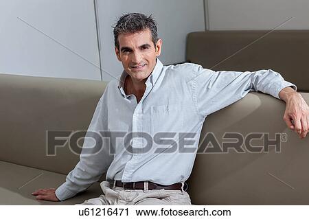 Man sitting and looking at camera View Large Photo Image Stock Image - Man sitting and looking at camera. Fotosearch
