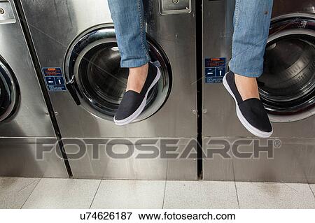 Man sitting on top of the washing machine View Large Photo Image Stock Photo - Man sitting on top of the washing machine. Fotosearch