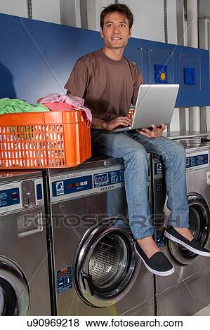 Man sitting on top of the washing machine View Large Photo Image Stock Photo - Man sitting on top of the washing machine. Fotosearch