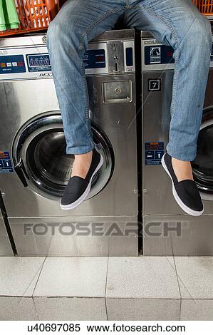 Man sitting on top of the washing machine View Large Photo Image Stock Photography - Man sitting on top of the washing machine. Fotosearch