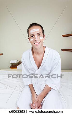 Stock Image - Man sitting with cream on her face. Fotosearch