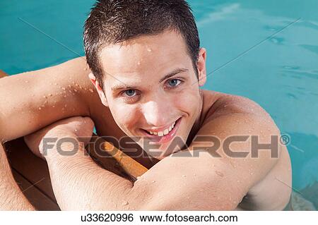 Stock Photograph - Man smiling in the edge of the pool. Fotosearch