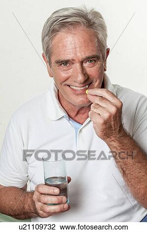 Man taking a pill View Large Photo Image Stock Image - Man taking a pill. Fotosearch