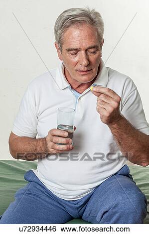 Man taking a pill View Large Photo Image Stock Photograph - Man taking a pill. Fotosearch