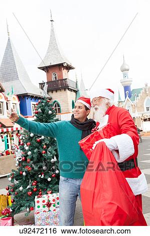 Man taking a selfie with santa claus View Large Photo Image Stock Photograph - Man taking a selfie with santa claus. Fotosearch