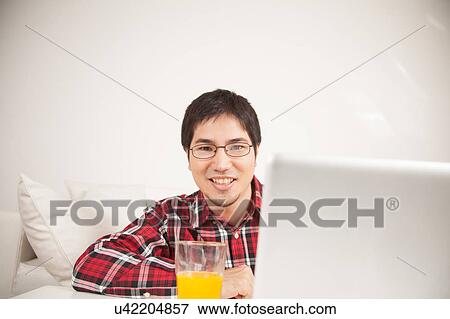 Stock Photo - Man using the computer and looking at camera. Fotosearch