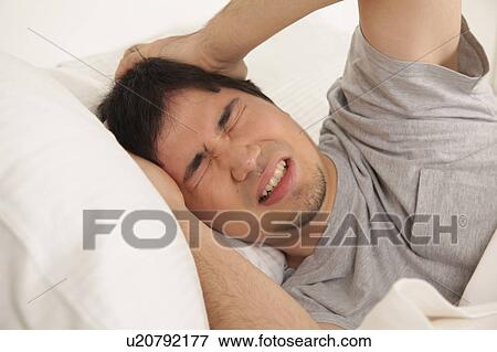 Stock Photo - Man waking up with headache. Fotosearch