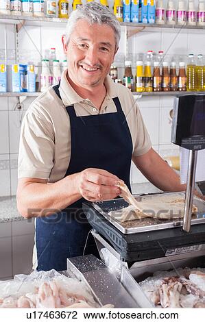 Man weighing a piece of fish View Large Photo Image Stock Image - Man weighing a piece of fish. Fotosearch