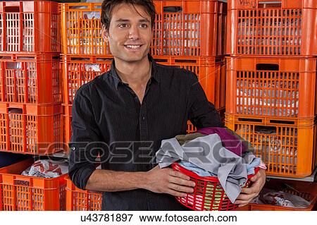 Stock Photo - Man with baskets in the laundry. Fotosearch