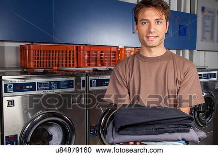 Man with clothes in the laundry View Large Photo Image Stock Image - Man with clothes in the laundry. Fotosearch