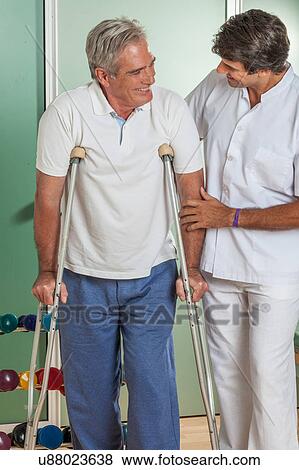 Man with his doctor rehabiliting View Large Photo Image Stock Photo - Man with his doctor rehabiliting. Fotosearch
